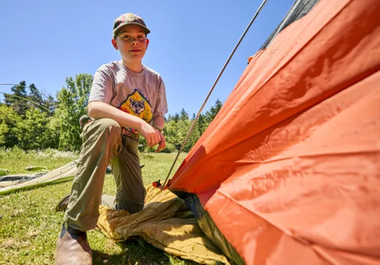 Cub Scout in uniform at campsite